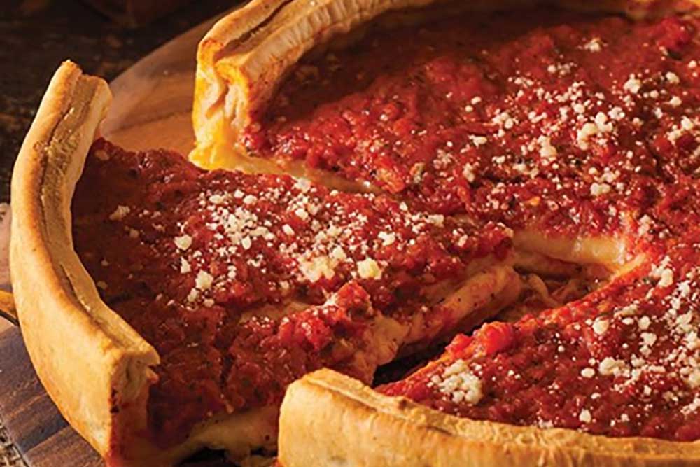 a close up of a deep dish pizza from Pequods, on our Best Deep Dish Pizza In Chicago list
