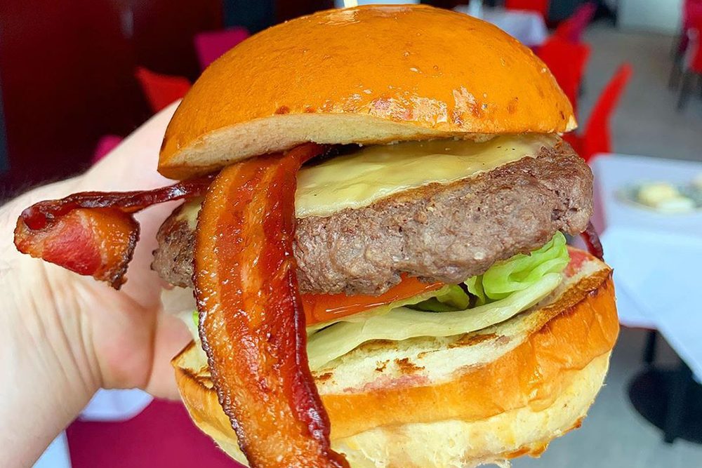close-up of a burger with a brioche bun from Rebellion, featured in our Best Burgers in Washington DC guide