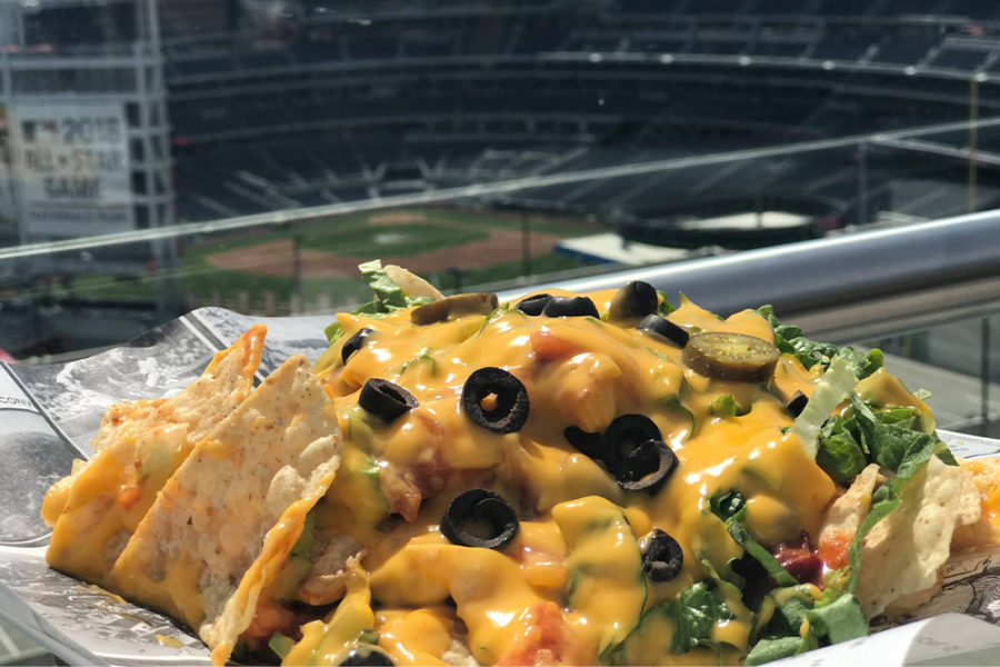 nachos topped with cheese, olives, and other greens