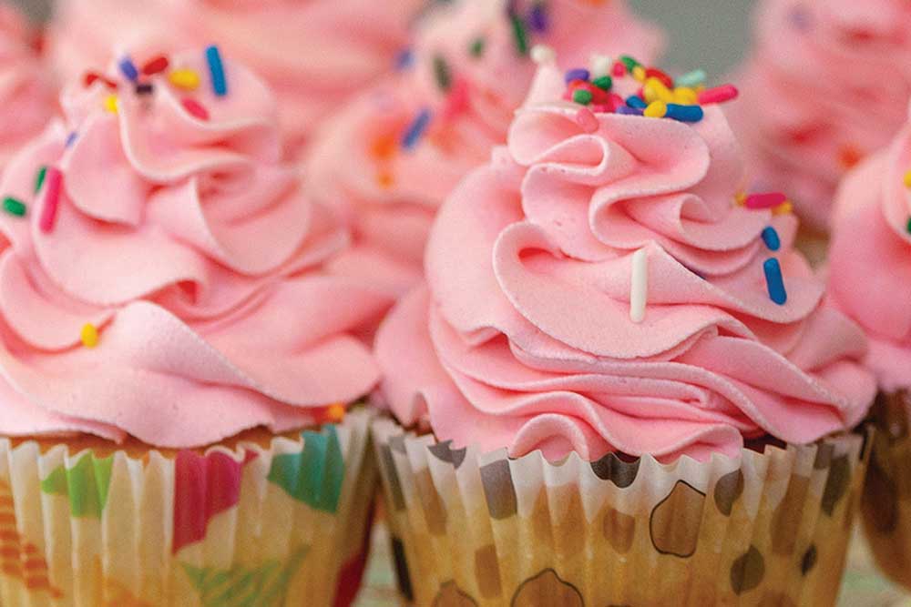 close-up of two cupcakes with pink frosting and sprinkles