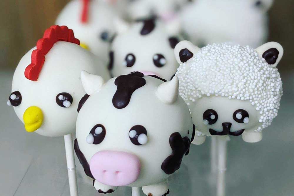 Cake pops with designs of cows, chickens, and sheep