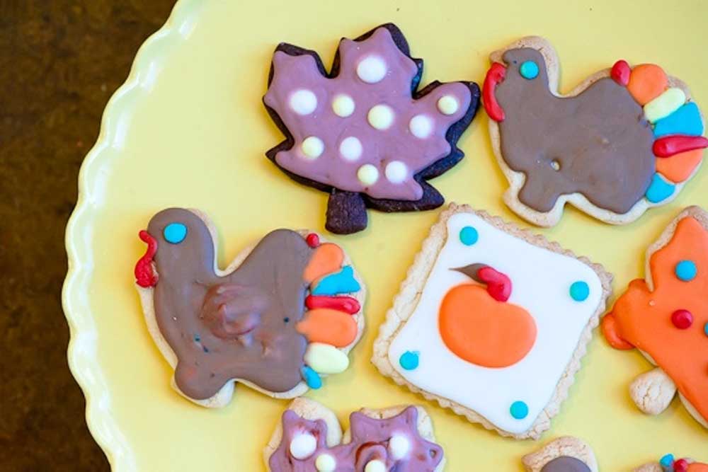 Cookies in various shapes (turkeys, leaves, etc.) on a yellow dish