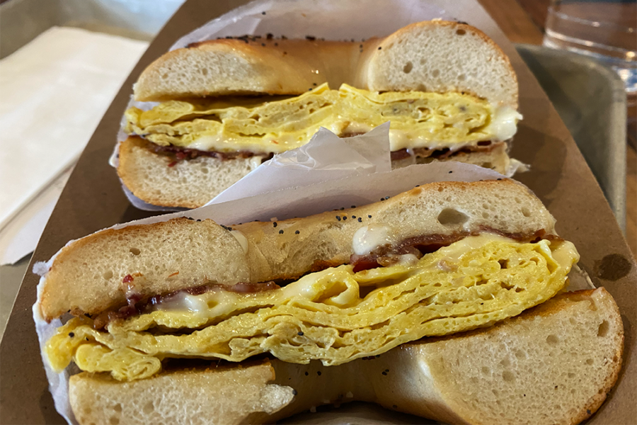 Bacon, egg, and cheese bagel sandwich on everything bagel, split in half and facing forward