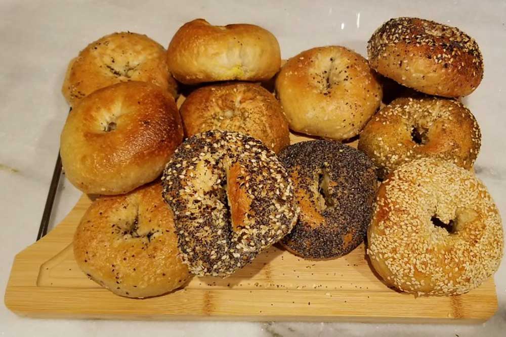 Several types of bagels on a wood cutting board