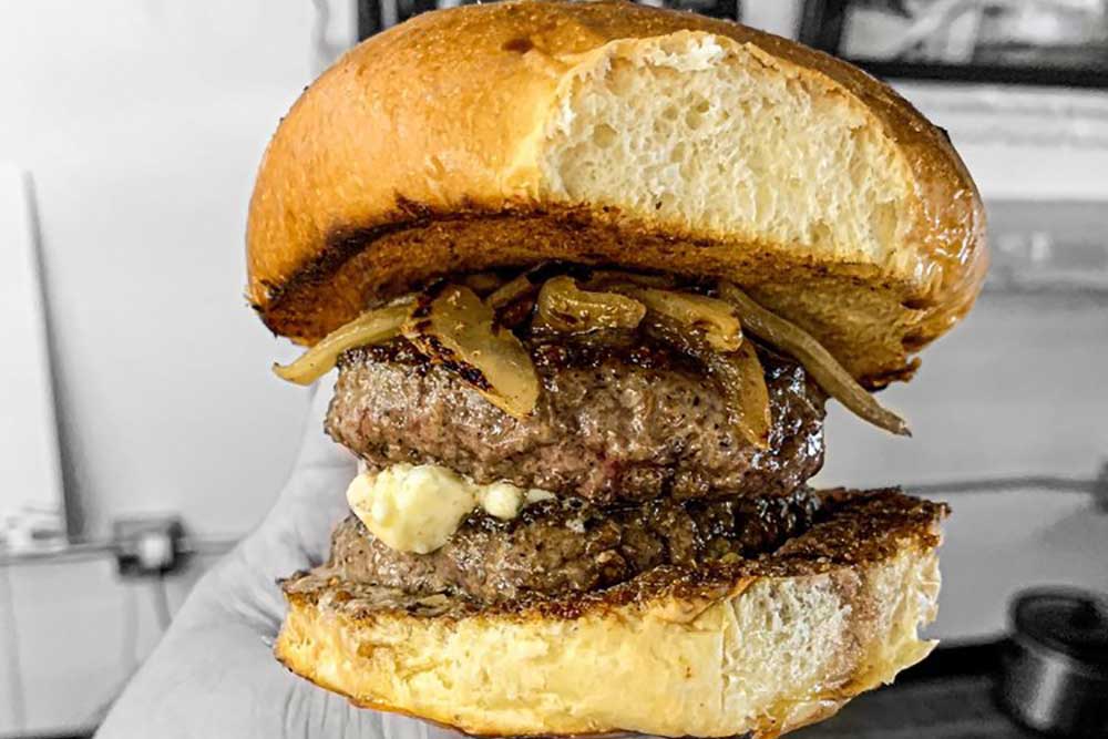 a juicy burger with two meat patties from the boozy pig in tampa, florida