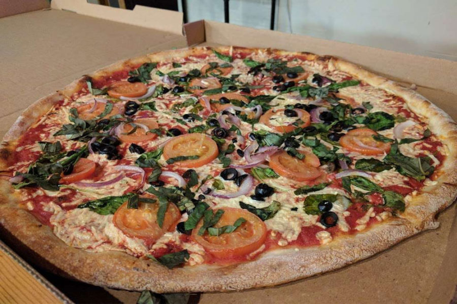 Pizza with tomatoes, onions, and olives from Pizzeria Luigi in san diego