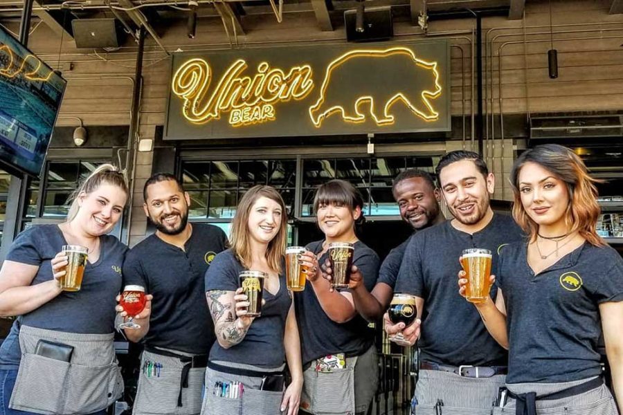 the staff of union bear brewing holding beers in dallas