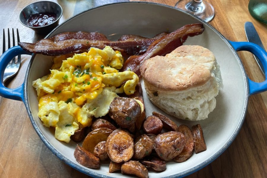 breakfast plate with eggs, bacon, sausage, and a biscuit from haymaker in charlotte