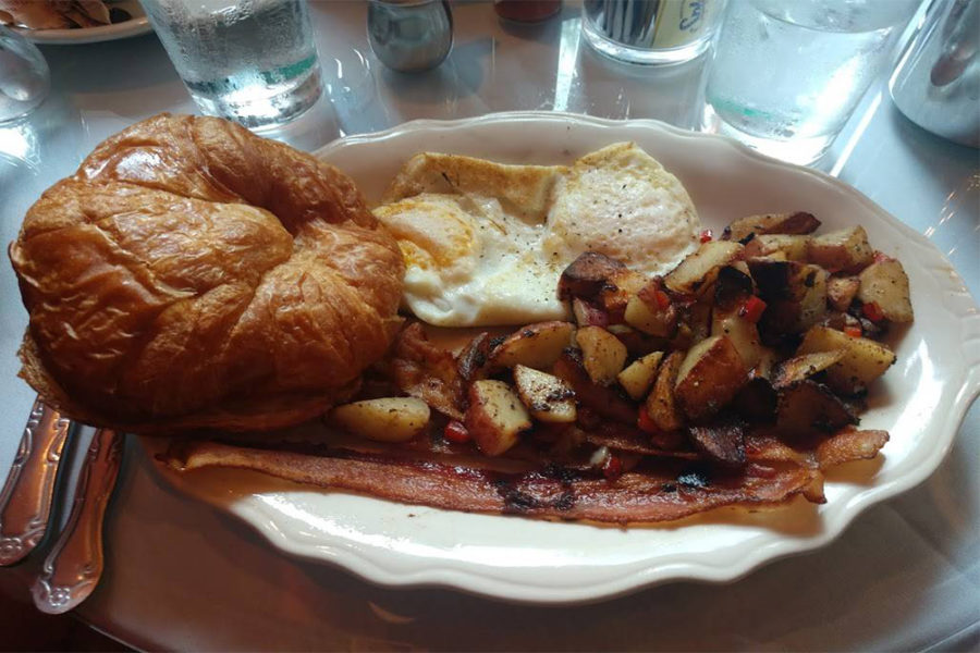 breakfast plate with croissant bread, bacon, potato wedges, and egg from cafe intermezzo in nashville