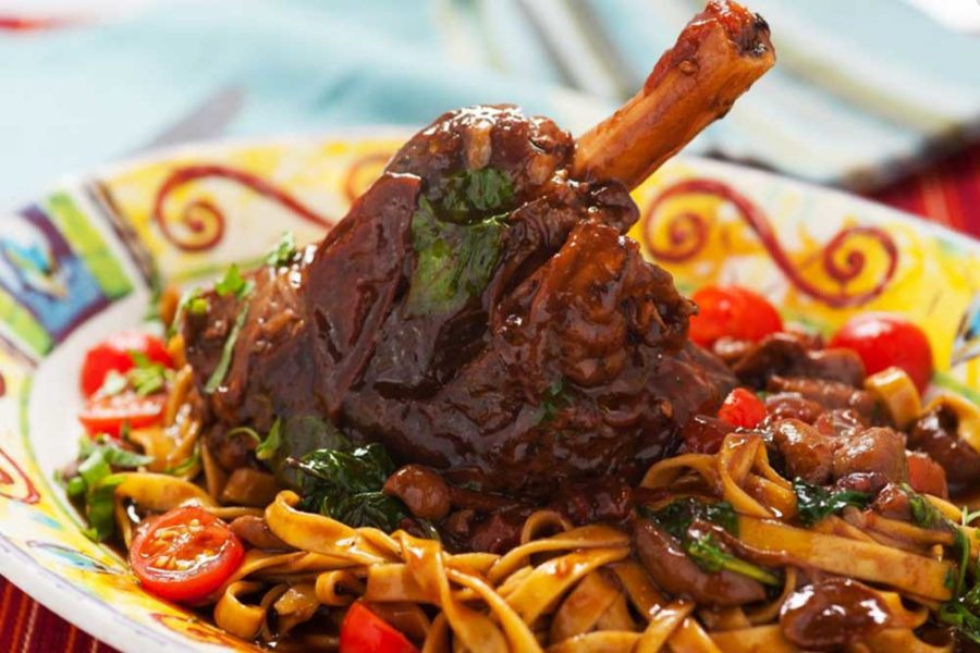lamb shank on top of red sauce pasta from cafe prima pasta in miami
