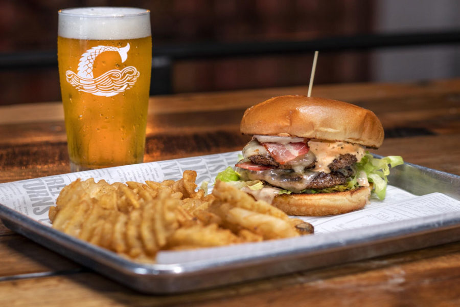 a glass of beer, burger, and a side of fries from coppertail brewing co. in tampa