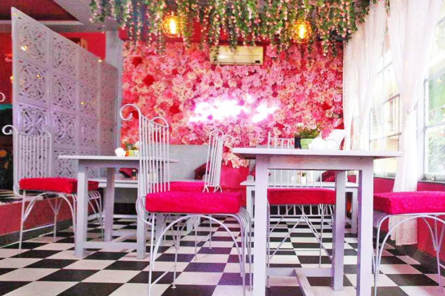 the interior at pink rose cafe in san diego with checkered flooring and a rose wall