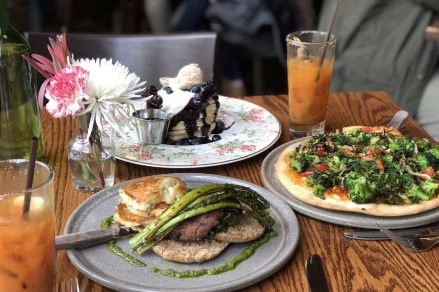 pita topped with greens, a stack of blueberry pancakes, a deconstructed burger, and iced coffees from plum bistro in seattle