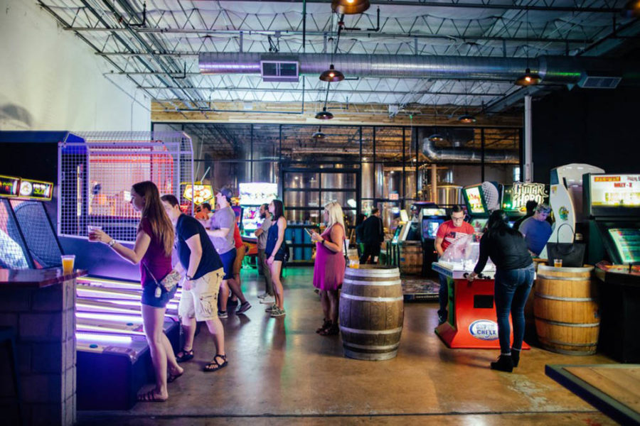 people enjoying the arcade games at cidercade in dallas