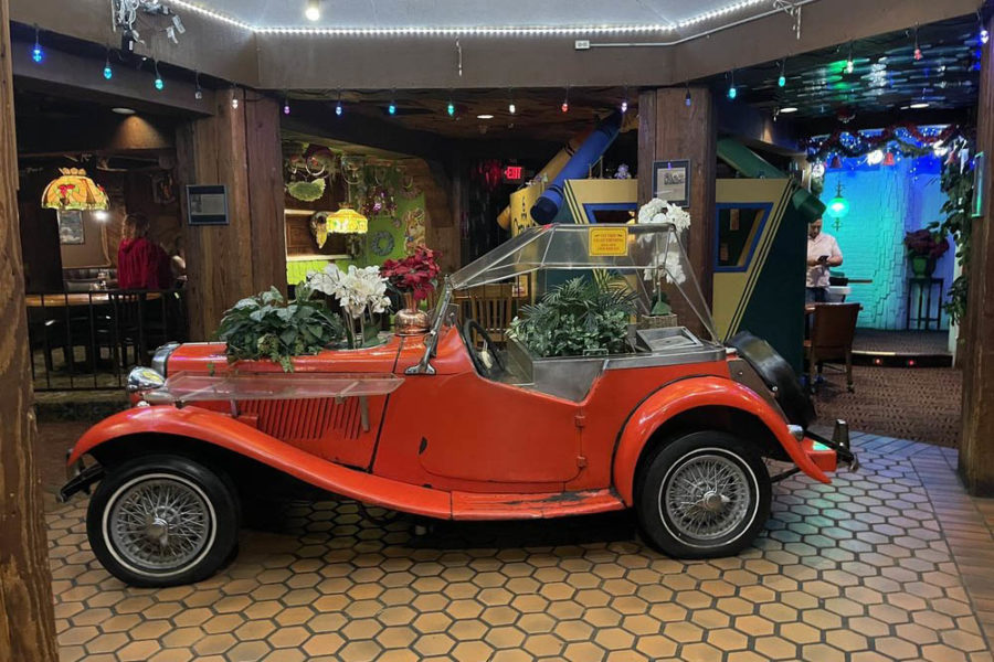 antique car filled with flowers and greenery at the magic time machine in dallas