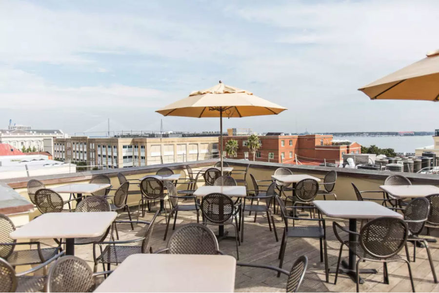 outdoor dining area at the rooftop at the vendue with a view of downtown Charleston