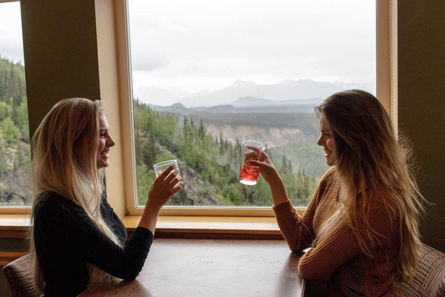 Diners enjoy a cocktail with a view of Denali National Park at Alpenglow in Alaska