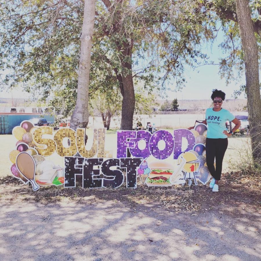 An attendee poses in front of a sign at the Soul Food Festival in Dallas, TX