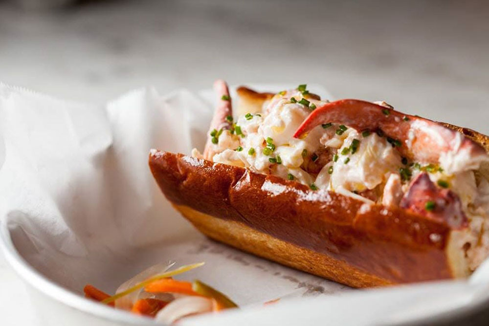 A lobster roll on a dish with a white lining