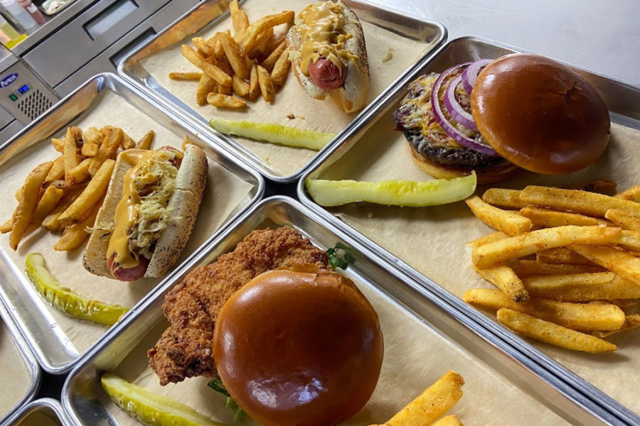 chicken sandwich, burger, and hotdogs with sides of fries