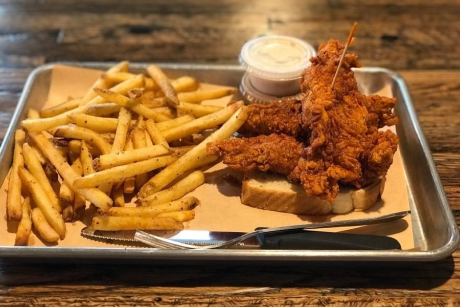 toast topped with fried chicken with a side of fries from the cookshack in college station