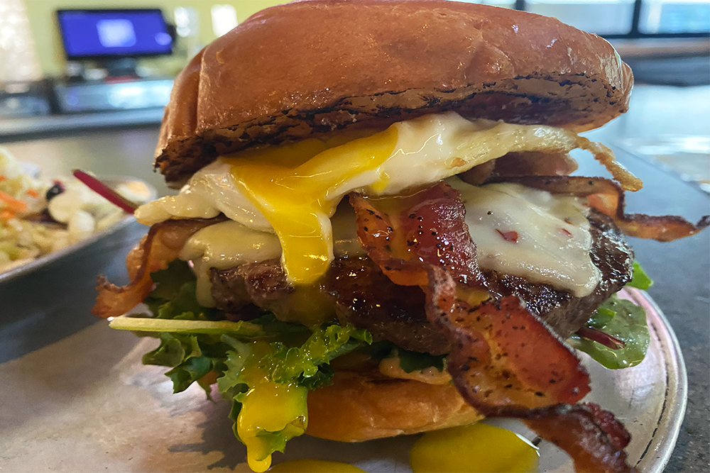 Brewlee Burger with fried egg, peppered bacon, pepper jack, fresh leafy greens, pickled red onion, sriracha Mayo, and caramelized sugar from Angel’s Trumpet Ale House in Phoenix, Arizona