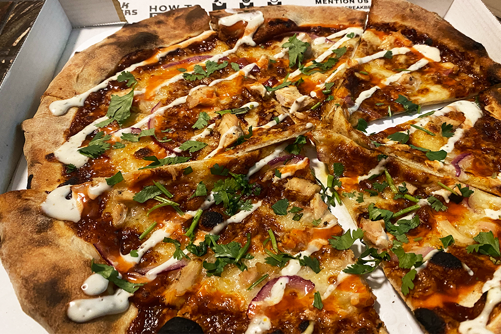 Buffalo BBQ Fusion pizza with BBQ base, mozzarella, grilled chicken, red onions, ranch drizzle, and buffalo swirl with fresh cilantro from Freak Bros Pizza in Phoenix, Arizona