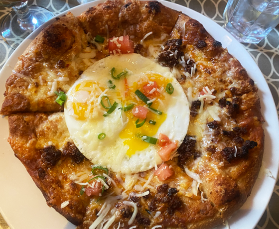 Breakfast pizza with chorizo, cheese, and a fried egg on top