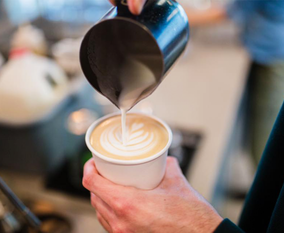 Steamed milk being poured on top of a latte