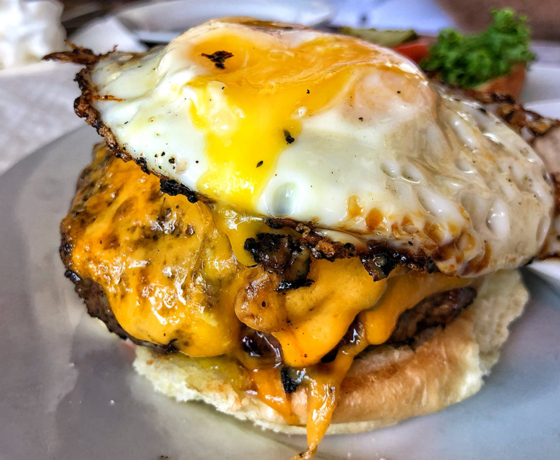 A cheeseburger with a fried egg on top
