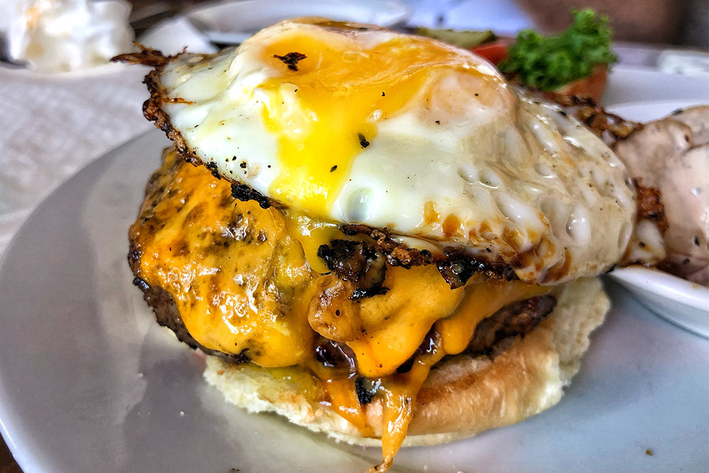 A cheeseburger with a fried egg on top