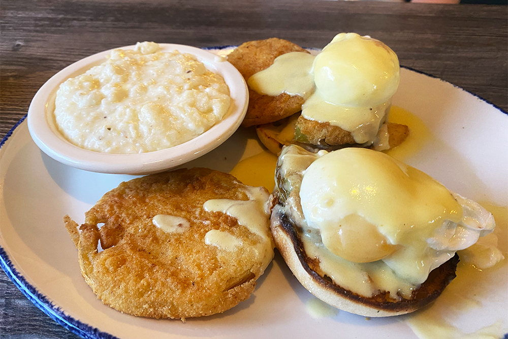 English muffins with poached eggs, fried green tomatoes, and a bowl of grits