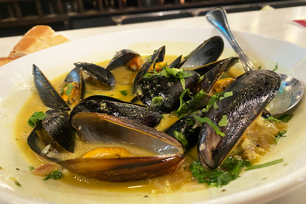 Mussels in a curry broth topped with cilantro