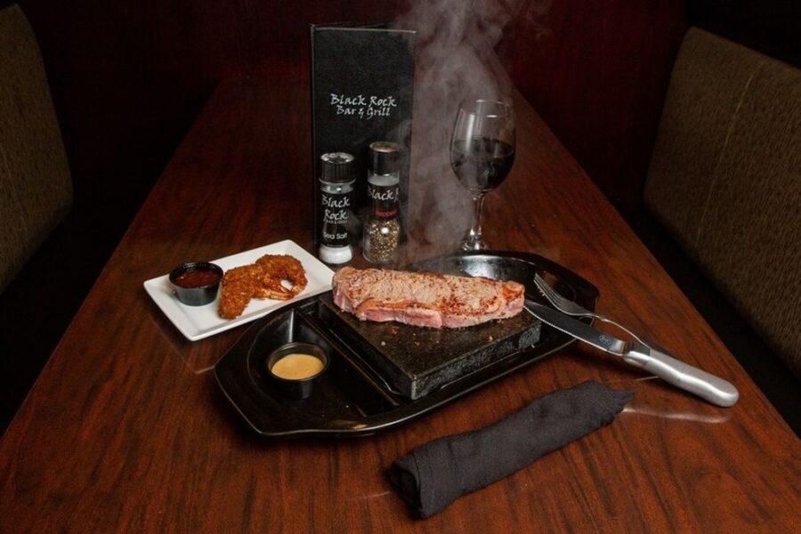 steak being cooked on lava rock from Black Rock Bar and Grill in Tampa, Florida