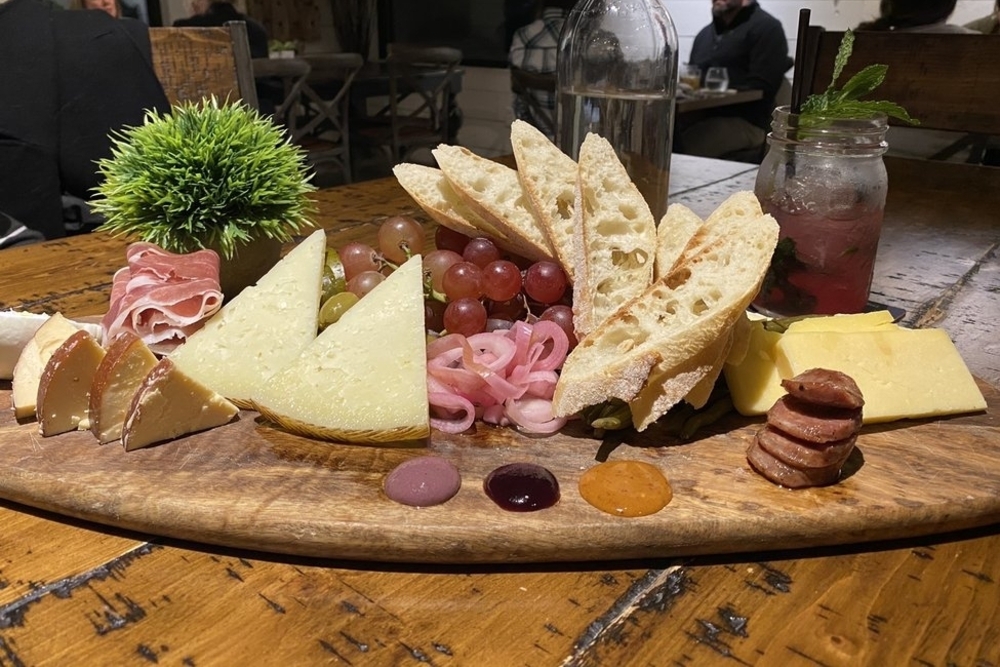 charcuterie board with various cheeses, meats, and grapes from The C House in Tampa